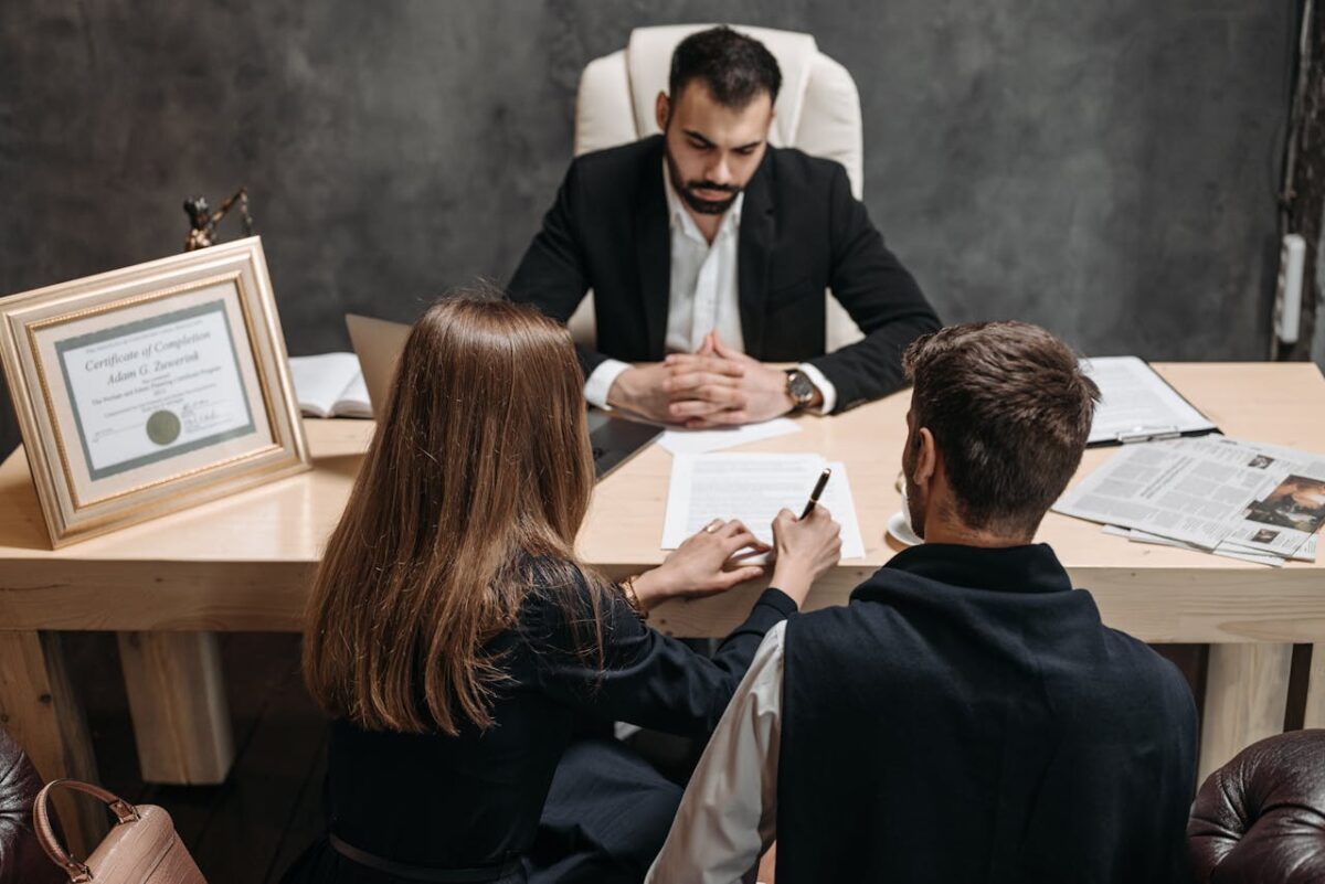 A lawyer discusses legal documents with clients in an office setting.